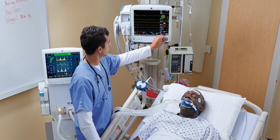 Un cuidador utiliza el monitor de CARESCAPE B650 de GE Healthcare para realizar la monitorización de los pacientes en una sala del hospital.
